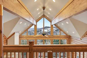 Detailed view of recessed lighting, rustic walls, beamed ceiling, and ceiling fan