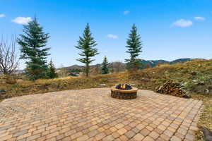 View of patio / terrace with a fire pit and a mountain view