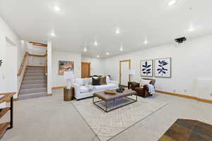 Living area featuring stairs, carpet floors, and recessed lighting