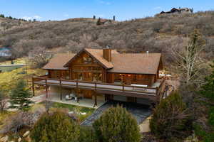 Back of house featuring a shingled roof and a chimney