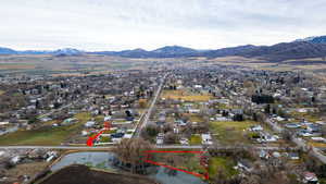 Aerial view of residential area featuring a mountainous background and property boundaries highlighted