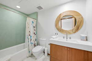 Full bathroom featuring vanity, shower / bathtub combination with curtain, light tile patterned flooring, and recessed lighting