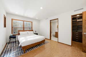 Bedroom with a walk in closet and recessed lighting