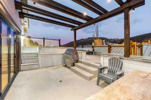 Patio terrace at dusk with an outdoor kitchen and a patio