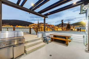 Patio terrace at dusk with a mountain view, grilling area, and a patio area