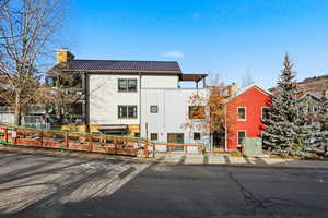 View of front of home with a chimney and a metal roof