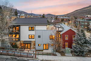 Rear view of property with a metal roof, a mountain view, and stone siding
