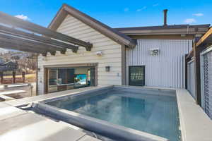 View of swimming pool featuring a patio area, a pergola, and a hot tub