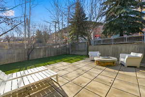 Fenced backyard featuring a fire pit and a patio area