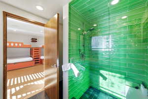 Ensuite bathroom with tiled shower and recessed lighting