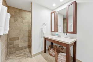 Bathroom with walk in shower, recessed lighting, vanity, and light tile patterned floors
