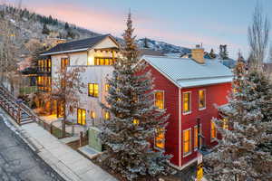 Property exterior at dusk with a chimney, a metal roof, a mountain view, and a gate