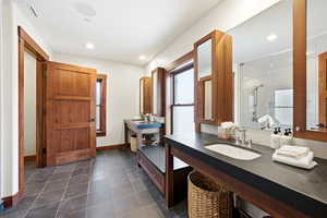 Full bathroom with a shower with door, dark tile patterned floors, and recessed lighting