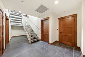 Foyer entrance with stairway, recessed lighting, and stone tile flooring