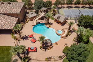 View of pool with a pool with connected hot tub, a patio, and a water slide