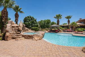 View of swimming pool featuring an in-ground hot tub, a patio area, and an outdoor living space