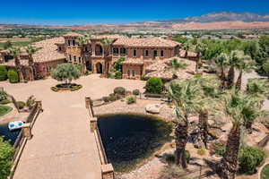View of front facade featuring stone siding, a mountain view, a balcony, and stucco siding