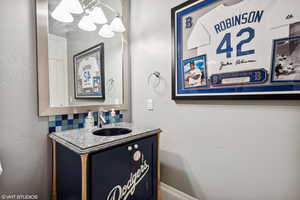 Bathroom featuring vanity, tasteful backsplash, and a chandelier