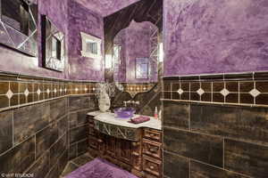Bathroom featuring tile walls, vanity, and wainscoting
