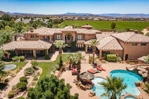 Aerial view of property and surrounding area featuring a mountain backdrop and a pool