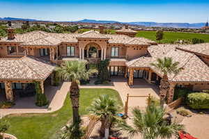 Mediterranean / spanish-style home with a front yard, a patio, stucco siding, a mountain view, and a chimney