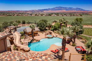 View of swimming pool with a patio area, a mountain view, a fenced backyard, and a pool with connected hot tub