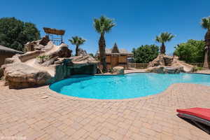 View of pool with a water slide and a patio area