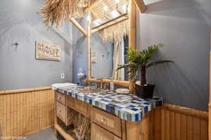 Bathroom featuring wainscoting, vanity, and wooden walls