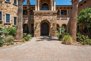 Property entrance with stone siding and stucco siding