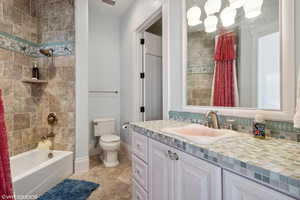 Bathroom with vanity, shower / bath combination with curtain, tasteful backsplash, and light tile patterned floors
