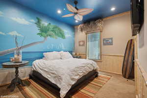 Carpeted bedroom with wainscoting, wood walls, recessed lighting, and a ceiling fan