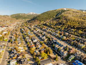 Aerial view of property and surrounding area with a mountainous background and nearby suburban area