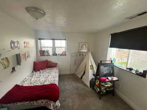 Bedroom featuring dark carpet and baseboards