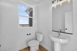 Half bath featuring baseboards and wood finished floors