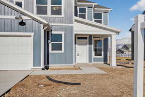 Property entrance featuring a porch and a garage