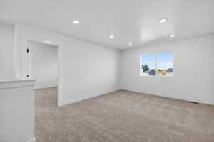 Empty room featuring light colored carpet and recessed lighting