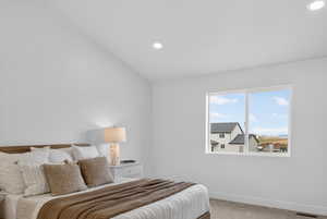 Bedroom with lofted ceiling, light colored carpet, and recessed lighting