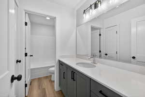 Full bath with vanity, light wood-style flooring, and washtub / shower combination