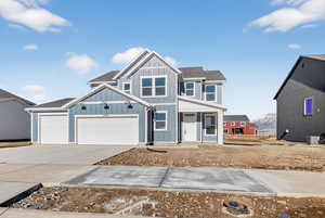 View of front of home featuring a porch, driveway, an attached garage, and roof with shingles