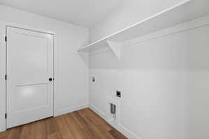 Washroom with wood finished floors, washer hookup, and hookup for an electric dryer