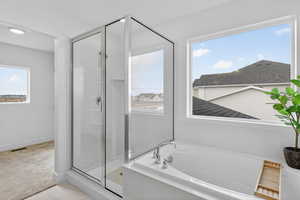 Bathroom featuring a shower stall and a bath