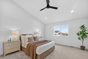 Carpeted bedroom with vaulted ceiling, a ceiling fan, and recessed lighting