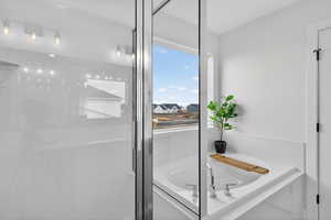 Full bathroom featuring a garden tub and a shower stall