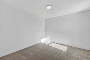 Unfurnished room featuring carpet floors and baseboards