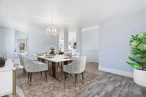 Dining space with suspended lighting and light wood-type flooring