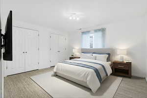 Bedroom featuring light colored carpet and two closets
