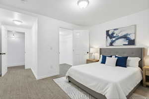 Bedroom with light carpet and a walk in closet