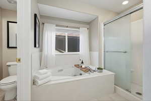 Bathroom with a shower stall, a whirlpool tub, and light tile patterned flooring