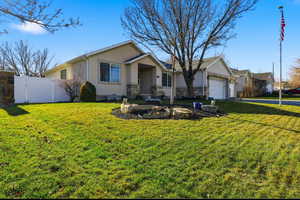 Single story home featuring stucco siding, a garage, a gate, and stone siding
