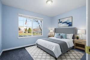 Bedroom featuring carpet and baseboards